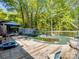 Backyard pool covered with a tarp, surrounded by a wooden deck, offering a private retreat in nature at 7624 Cedarbrook Dr, Charlotte, NC 28215