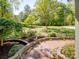 An outdoor patio area with a brick design and lush landscaping, creating a peaceful backyard retreat at 7624 Cedarbrook Dr, Charlotte, NC 28215