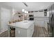 Open kitchen with a large center island, modern pendant lighting, and stainless appliances at 7624 Cedarbrook Dr, Charlotte, NC 28215