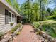 The walkway is lined with beautiful garden beds and brick design leading to a green lawn at 7624 Cedarbrook Dr, Charlotte, NC 28215