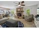 Open-concept living room with stone fireplace, wood floors, and views into the kitchen at 7624 Cedarbrook Dr, Charlotte, NC 28215