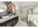 Elegant bathroom with a double sink vanity, modern fixtures, decorative wallpaper, and a separate soaking tub and shower at 10773 Sapphire Trl, Davidson, NC 28036