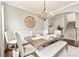 Charming dining room with wainscoting, a rustic wood table, an ornate chandelier, and a view of the staircase at 10773 Sapphire Trl, Davidson, NC 28036