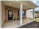 Inviting covered front porch featuring a seating area and stylish brick columns at 10773 Sapphire Trl, Davidson, NC 28036