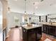 Bright kitchen featuring granite island, dark cabinets and open floor plan to dining and living area at 10773 Sapphire Trl, Davidson, NC 28036