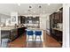 This spacious kitchen features dark cabinets, granite countertops, a central island with seating, and stainless steel appliances at 10773 Sapphire Trl, Davidson, NC 28036