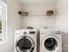 Well-lit laundry room featuring modern appliances and storage shelf, for your convenience at 10773 Sapphire Trl, Davidson, NC 28036