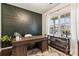 Well-lit office featuring a modern accent wall, a spacious wooden desk, and a large window with neighborhood views at 10773 Sapphire Trl, Davidson, NC 28036