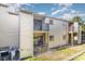 Exterior view of a multi-story townhouse with balconies, tan siding, and lush landscaping at 11063 Running Ridge Rd, Charlotte, NC 28226