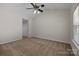 Spacious bedroom with neutral carpet, a ceiling fan, and ample closet space at 11929 Kings Castle Ct, Charlotte, NC 28277