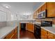 Spacious kitchen with stainless steel appliances, wood cabinets, and dark wood floors at 11929 Kings Castle Ct, Charlotte, NC 28277