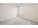 Bright bedroom featuring neutral carpet, white walls, and a double-hung window at 124 N Shayna Rd, Troutman, NC 28166