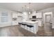 Bright kitchen features white cabinets, stone backsplash, stainless appliances, and a large center island at 124 N Shayna Rd, Troutman, NC 28166