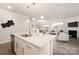 Open-concept home features kitchen island, dining area, and living room with fireplace at 124 N Shayna Rd, Troutman, NC 28166