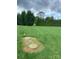 Large backyard with mature trees, green grass and two manhole covers at 139 Sain Rd, Statesville, NC 28625