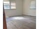 A bedroom with two windows and damaged floors is seen from the doorway at 143 Harvest Dr, Kings Mountain, NC 28086