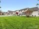 Large backyard showcasing a well-maintained lawn and a charming white picket fence at 14923 Colonial Park Dr, Huntersville, NC 28078