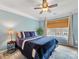 Well-lit bedroom with a blue color scheme, ceiling fan, and window with wood blinds at 14923 Colonial Park Dr, Huntersville, NC 28078