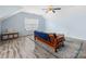 Bright bonus room with hardwood flooring, featuring a futon, a window with blinds, and an area rug at 14923 Colonial Park Dr, Huntersville, NC 28078