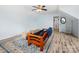 Bonus room with a futon, blue area rug, wood floors, an open layout, and a ceiling fan for comfort at 14923 Colonial Park Dr, Huntersville, NC 28078