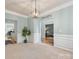 Elegant dining room with wainscoting, neutral carpet, and a stylish chandelier at 14923 Colonial Park Dr, Huntersville, NC 28078
