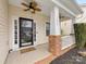 Close-up of a welcoming front porch with brick accents, ceiling fans, and a decorative front door at 14923 Colonial Park Dr, Huntersville, NC 28078