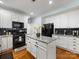 Stylish kitchen with white cabinets, granite countertops, black appliances, and hardwood floors at 14923 Colonial Park Dr, Huntersville, NC 28078