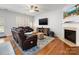 Inviting living room with a fireplace, hardwood floors, a mounted TV, and cozy seating at 14923 Colonial Park Dr, Huntersville, NC 28078