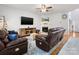 Comfortable seating in living room with a fireplace, hardwood floors, and a mounted TV at 14923 Colonial Park Dr, Huntersville, NC 28078
