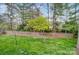 A green backyard with a picket fence, a small tree and some string lights at 1509 Burning Lantern Ln, Kannapolis, NC 28081
