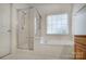 Bathroom featuring a glass enclosed shower and soaking tub under a window at 1509 Burning Lantern Ln, Kannapolis, NC 28081