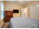 Neutral bedroom featuring a dresser, TV, and a door with a view to other rooms at 1509 Burning Lantern Ln, Kannapolis, NC 28081