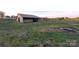 Side view of a barn situated on a property with open fields, showcasing its rural charm at 1524 J Rhyne Reep Rd, Vale, NC 28168