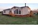 Exterior view of a home featuring tan vinyl siding, a dark roof, and a wooden porch at 1524 J Rhyne Reep Rd, Vale, NC 28168