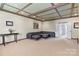 Finished basement with coffered ceilings, plush carpet, leather sectional, and walkout to the backyard at 16123 Chiltern Ln, Huntersville, NC 28078