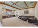 Basement with coffered ceilings, plush carpet, leather sectional, and custom-built in storage cabinets at 16123 Chiltern Ln, Huntersville, NC 28078