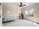 Cozy bedroom with neutral walls and carpet, a ceiling fan, and a window at 16123 Chiltern Ln, Huntersville, NC 28078