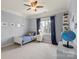 Cozy bedroom featuring a ceiling fan, plush carpet, and a large window that provides natural lighting at 16123 Chiltern Ln, Huntersville, NC 28078