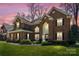 Charming brick two-story home with manicured lawn in the evening at 16123 Chiltern Ln, Huntersville, NC 28078