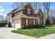 Side view of a brick two-story home with attached garages and green lawn at 16123 Chiltern Ln, Huntersville, NC 28078