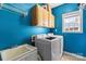 Bright laundry room with blue walls, washer, dryer, and cabinetry at 16123 Chiltern Ln, Huntersville, NC 28078