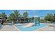 Community pool area featuring a splash pad, lounge chairs, and shaded seating, perfect for summer fun at 16123 Chiltern Ln, Huntersville, NC 28078