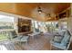 Relaxing screened porch with stone fireplace, ceiling fans, and comfortable seating for entertaining guests at 16123 Chiltern Ln, Huntersville, NC 28078