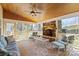Relaxing screened porch with stone fireplace, ceiling fan, and comfortable seating, ideal for outdoor living at 16123 Chiltern Ln, Huntersville, NC 28078