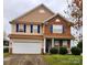 Charming two-story home with blue shutters, stone accents, attached garage, and landscaped yard at 16306 Hayfield Rd, Charlotte, NC 28213