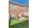 Backyard with patio, artificial turf, and a white fence, ideal for outdoor entertaining and relaxation at 165 Singleton Rd, Mooresville, NC 28117