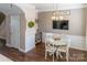 Charming dining area features a round table, white chairs, and modern lighting under a mounted TV at 165 Singleton Rd, Mooresville, NC 28117