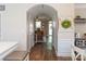 Hallway view of a cozy living room with brown couches, wood floors, and archway doors at 165 Singleton Rd, Mooresville, NC 28117