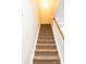 Carpeted staircase features a light wood railing and neutral walls, ascending to the upper level of the home at 165 Singleton Rd, Mooresville, NC 28117