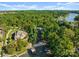 Aerial view of the waterfront property showcasing the home, lush landscaping, sandy beach, private dock, and lake access at 18420 Rosapenny Rd, Charlotte, NC 28278
